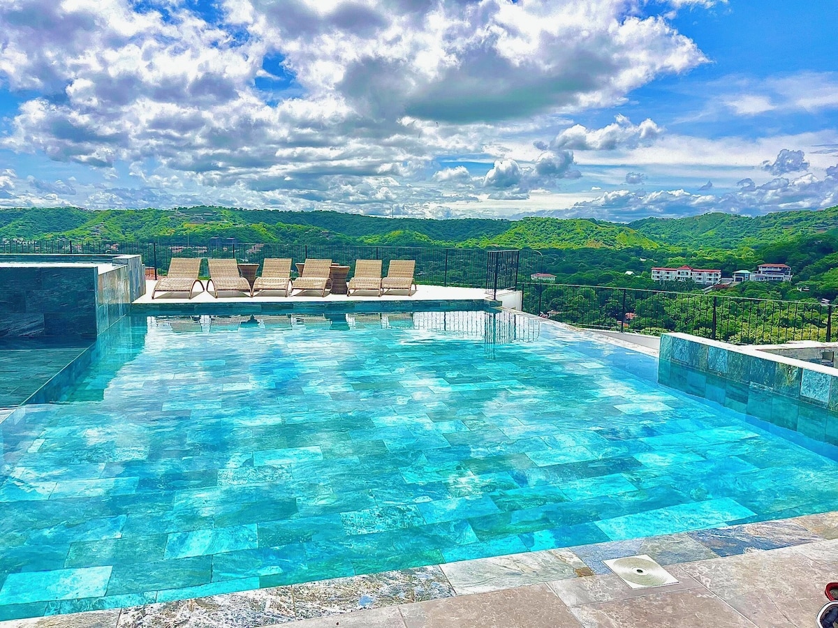 Infinity pool with lounge chairs and valley view
