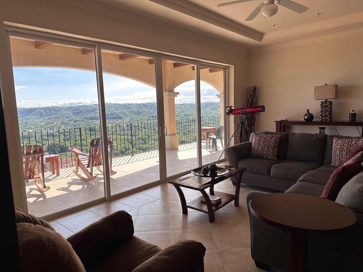 E201 living room with balcony and hillside views